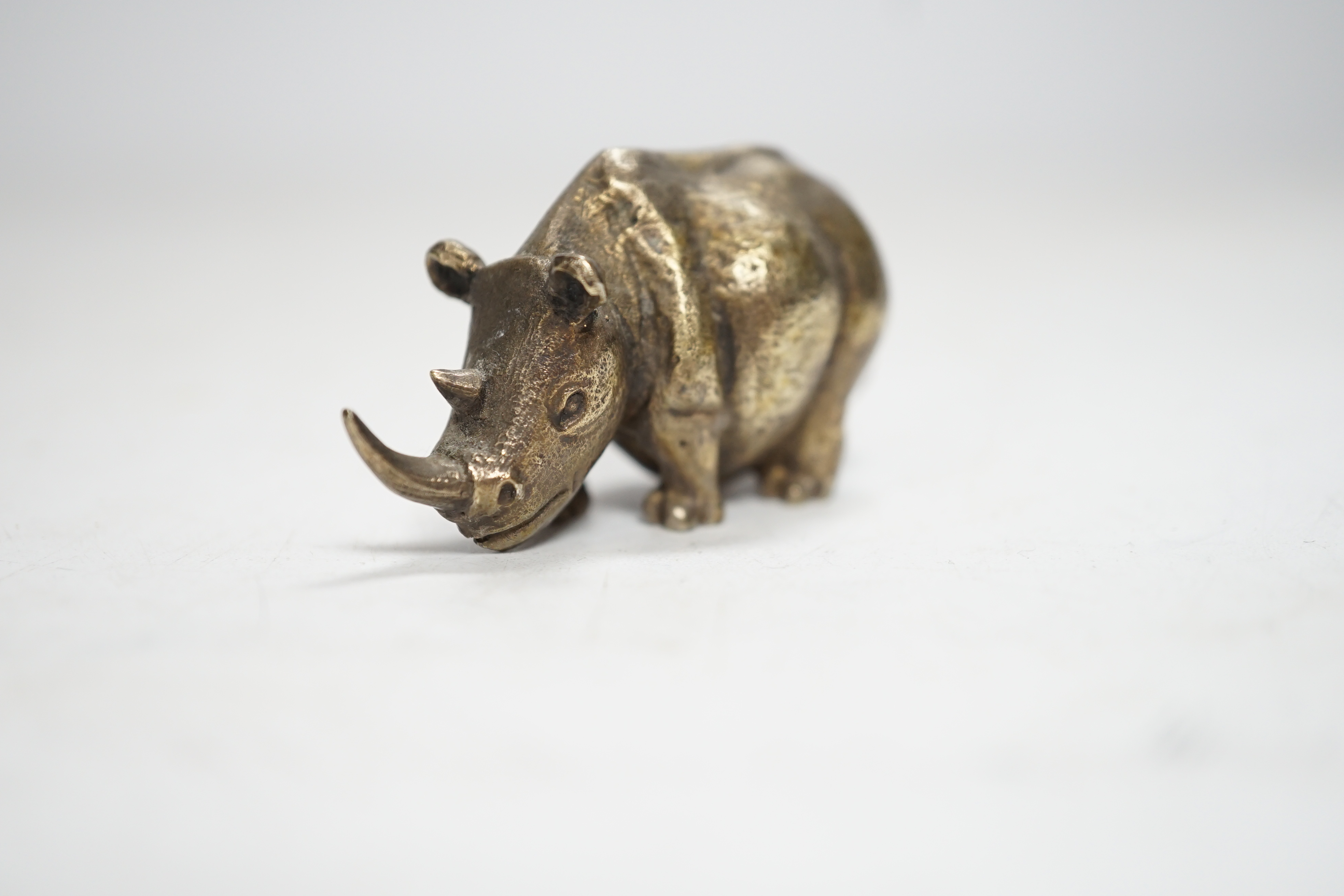 An Elizabeth II silver miniature model of a rhinoceros, by Stuart Devlin, London, 1985, length 55mm.